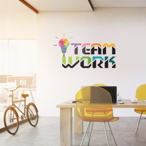نصب استیکر دیواری طرح لامپ رنگی و متن Teamwork روی دیوار سفید اتاق کنفرانس